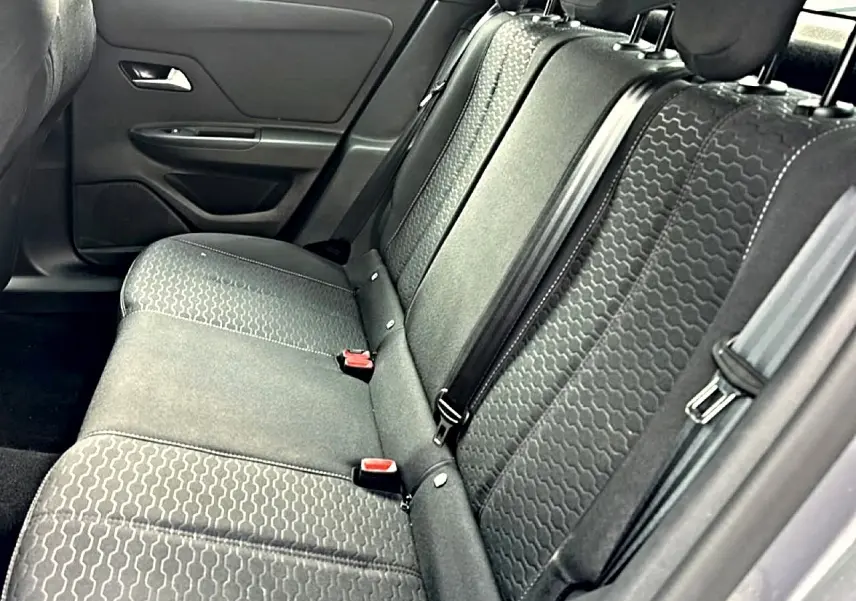 Vue latérale du siège arrière gris foncé de l'Opel Mokka 2025 avec motifs géométriques et ceintures visibles.