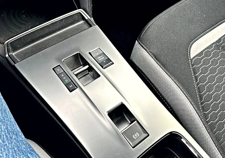 Vue rapprochée de la console centrale grise avec levier de vitesse automatique et siège tissu noir Opel Mokka 2025.