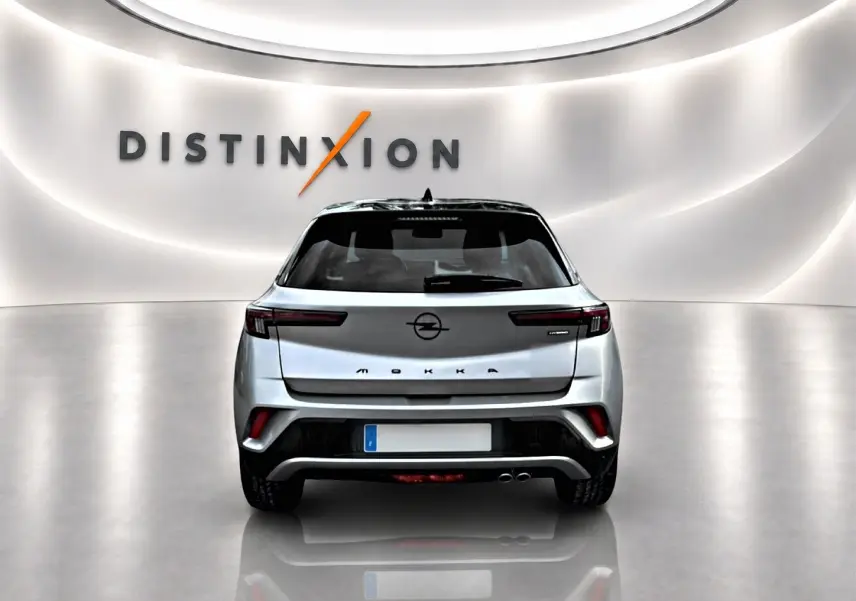 Vue arrière d'un Opel Mokka gris 2025 avec feux LED fins et double sortie d'échappement visible en studio.