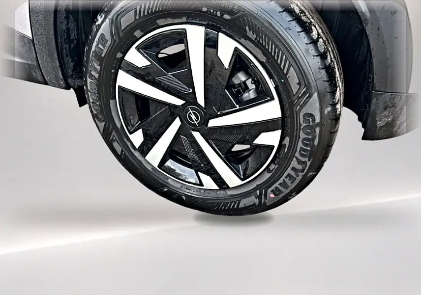 Gros plan sur la roue avant droite de l'Opel Mokka gris, jante noire et argentée au design moderne.
