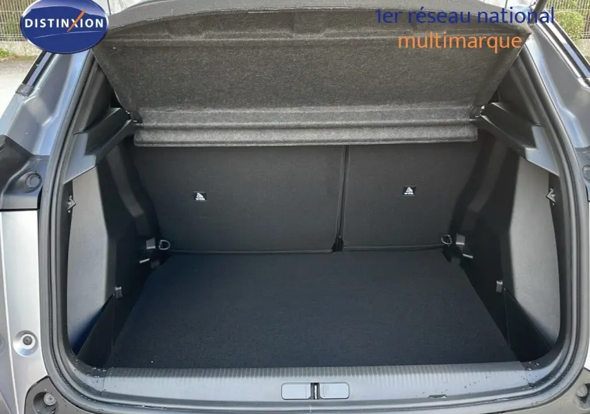 Coffre ouvert vu de l'arrière d'un Peugeot 2008 gris Artense métal, montrant l'espace de chargement vide et propre.