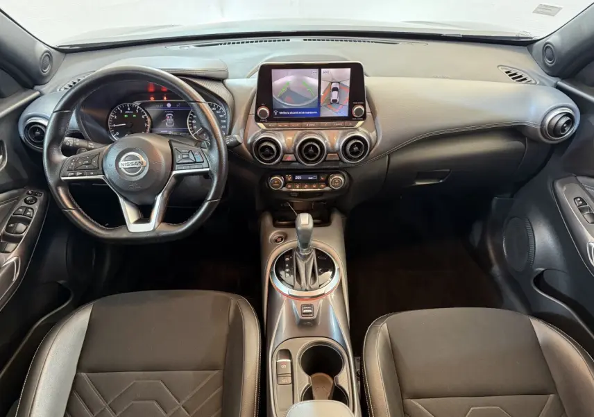 Intérieur du Nissan Juke Tekna 2021, vue frontale sur tableau de bord avec écran tactile et volant cuir noir.