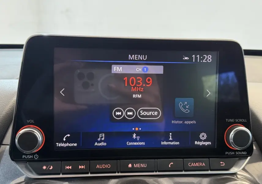 Écran tactile central du Nissan Juke Tekna 2021 affichant la radio FM 103.9 MHz avec commandes audio et téléphone.