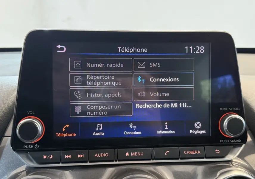 Écran tactile central du Nissan Juke Tekna 2021 affichant le menu téléphone avec commandes physiques en dessous