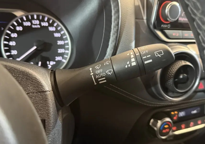 Gros plan sur la commande d’essuie-glace à gauche du volant dans l’habitacle gris du Nissan Juke Tekna 2021.