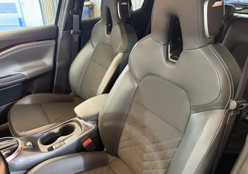Gros plan sur les sièges avant noirs en cuir et tissu du Nissan Juke Tekna 2021, avec logo Bose visible.