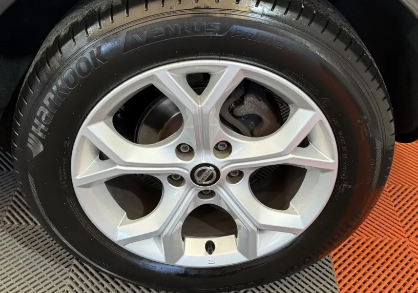 Gros plan sur la roue avant droite du Nissan Juke gris clair 2021 avec jante alliage et pneu neuf.