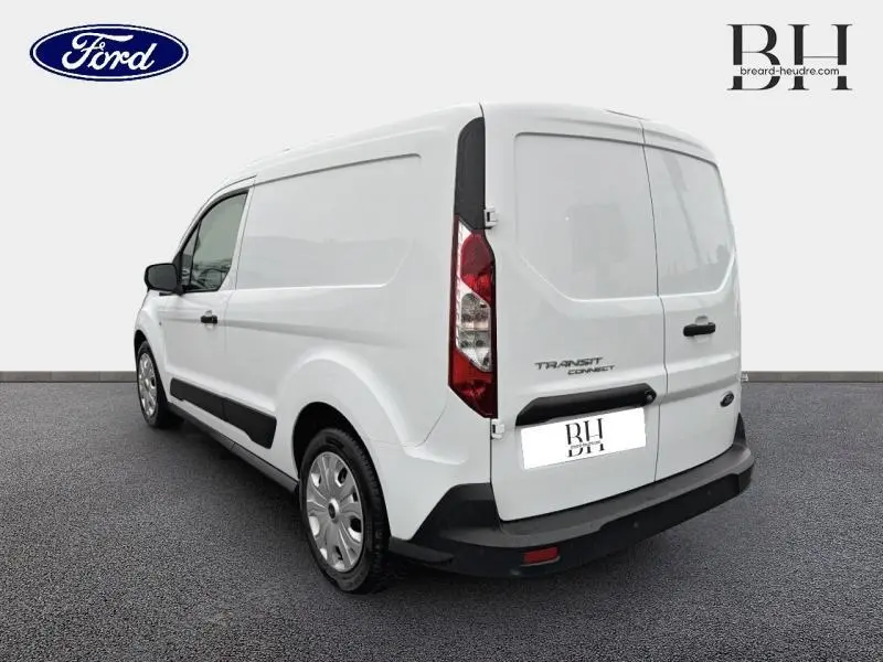 Vue 3/4 arrière droite d'un Ford Transit Connect blanc glacier avec portes arrière pleines et protections noires.
