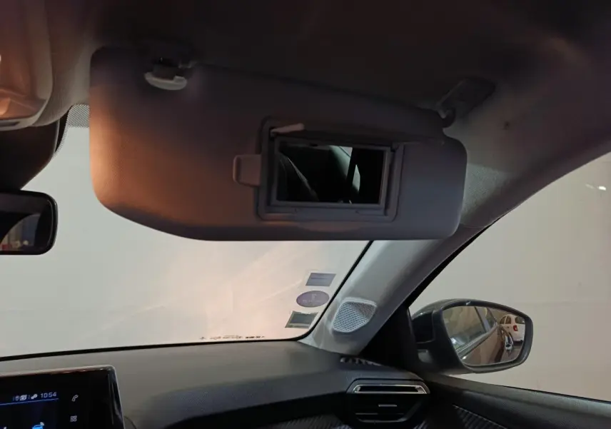 Intérieur de la Peugeot 208 1.2 PT 75 S&S Premium 2022, vue côté passager avec pare-soleil et miroir ouvert.