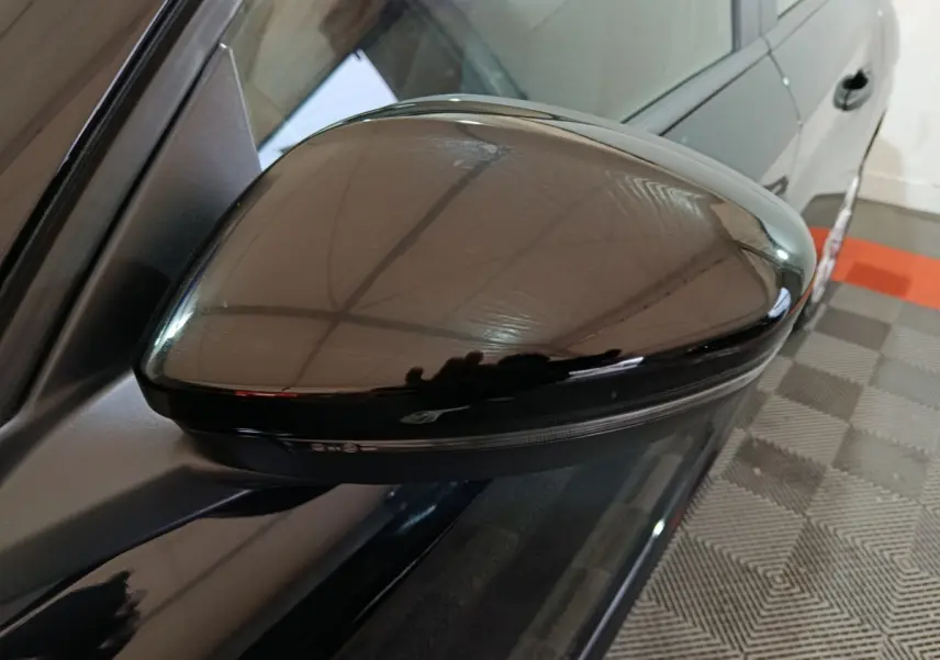 Rétroviseur côté gauche noir brillant de la Peugeot 208 1.2 PT 75 S&S Premium 2022, vue rapprochée en intérieur.