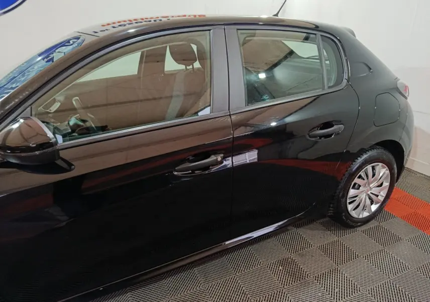Vue latérale gauche d'une Peugeot 208 noire 2022, mettant en valeur les portières et les jantes en alliage.