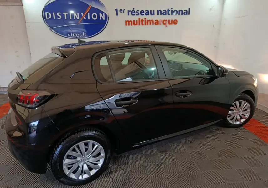 Peugeot 208 noire vue de profil côté droit dans un showroom avec jantes alliage et feux arrière LED.