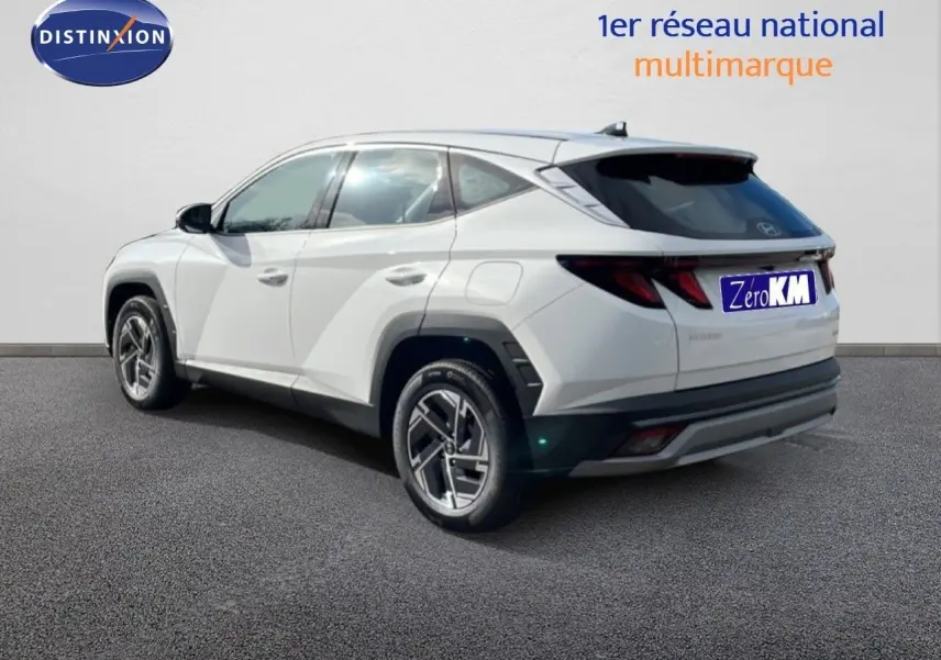Vue 3/4 arrière droite du Hyundai Tucson blanc Atlas, soulignant ses lignes anguleuses et ses jantes modernes.