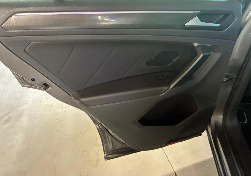 Vue rapprochée de la porte arrière droite gris foncé du Volkswagen Tiguan 2.0 TDI 190 4MOTION Carat Exclusive, intérieur noir.