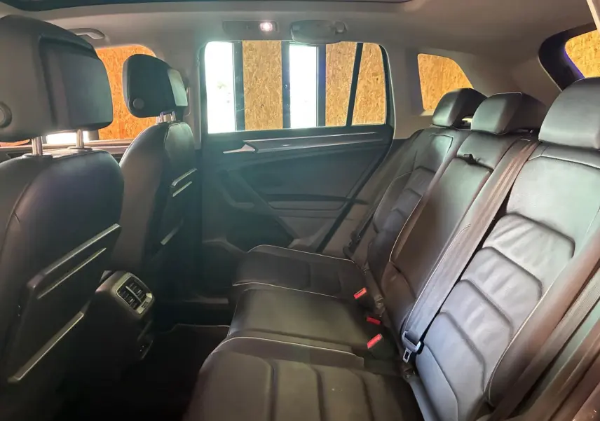 Vue intérieure arrière côté droit du Volkswagen Tiguan 2020, sièges en cuir noir et ceinture de sécurité visibles.