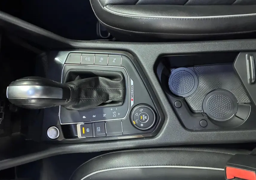 Vue rapprochée de la console centrale du Volkswagen Tiguan gris, avec levier de vitesses automatique et commandes 4MOTION visibles.