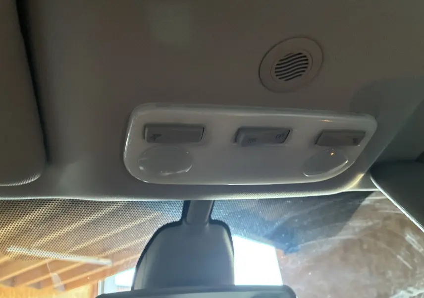 Vue intérieure du plafonnier blanc avec commandes d’éclairage au-dessus du rétroviseur central d’une Renault Mégane Coupé blanche.