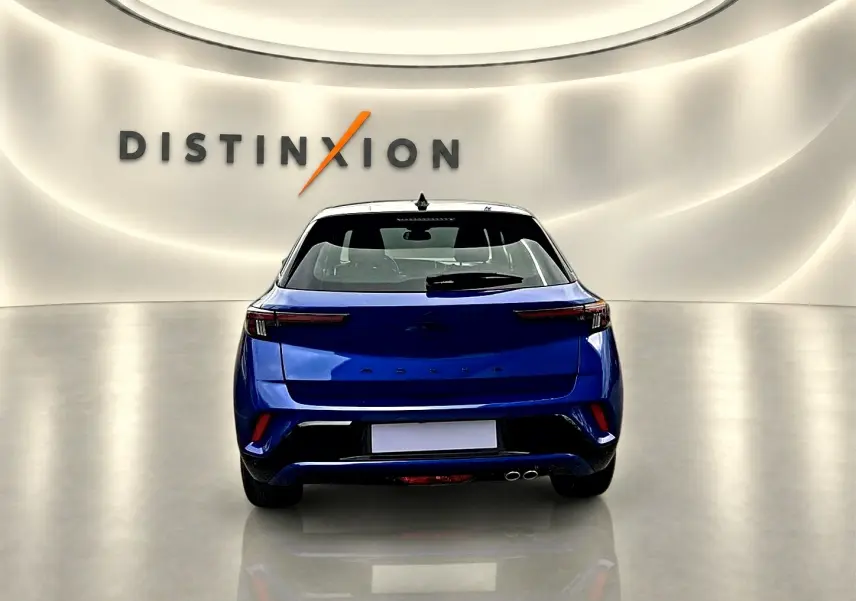 Vue arrière d'un Opel Mokka bleu 2025 dans un showroom avec double sortie d'échappement et feux LED fins.