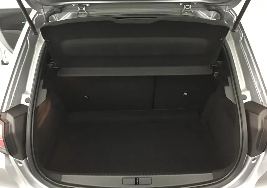 Coffre ouvert vu de l'arrière d'une Peugeot 208 gris artense, montrant l'espace de chargement vide et la trappe arrière.
