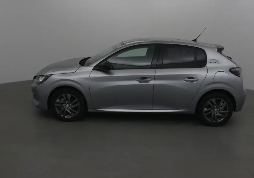 Profil côté gauche d'une Peugeot 208 gris Artense 2022 finition Style avec jantes alliage et vitres teintées.