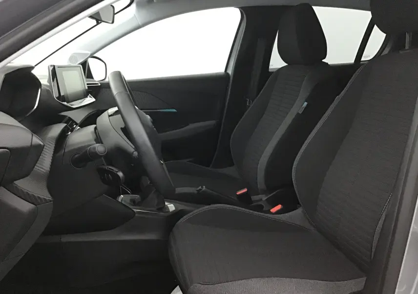 Intérieur avant droit de la Peugeot 208 1.2 PureTech 100 Style 2022, sièges noirs et tableau de bord moderne avec écran tactile.