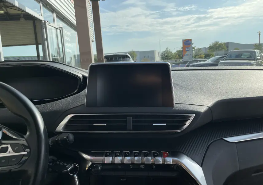 Tableau de bord du Peugeot 3008 blanc 2018 vu de face, écran tactile éteint et commandes métalliques en évidence.