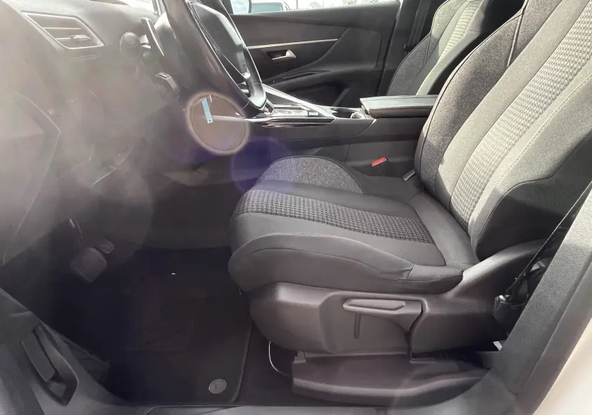 Vue intérieure côté conducteur du Peugeot 3008 blanc de 2018, mettant en valeur les sièges gris noir et la console centrale moderne.