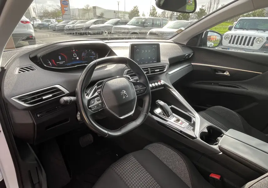 Vue intérieure côté conducteur du Peugeot 3008 blanc de 2018, avec tableau de bord numérique et écran tactile central.