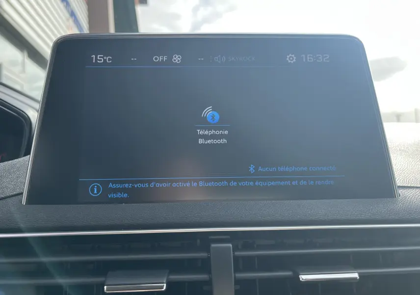 Écran tactile central du Peugeot 3008 blanc 2018 affichant la connexion Bluetooth, avec tableau de bord gris noir en arrière-plan.