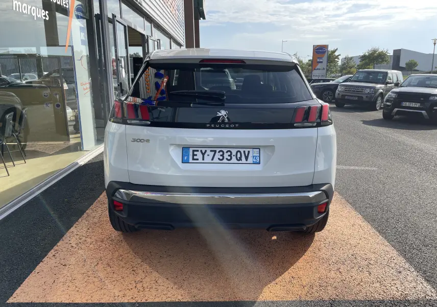 Vue arrière d'un Peugeot 3008 blanc de 2018 avec feux arrière noirs et plaque d'immatriculation française visible.