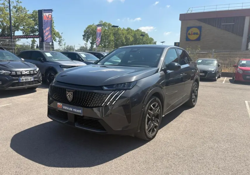 Peugeot 3008 Hybrid gris en 3/4 avant droit, avec calandre noire et jantes alliage 18 pouces visibles en extérieur.