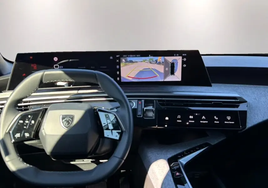Vue intérieure du tableau de bord du Peugeot 3008 bleu Ingara 2025, avec volant multifonction et écran tactile central affichant la caméra de recul.