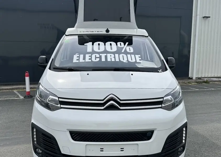 Vue de face du Citroën Jumpy van blanc avec toit relevable et inscription 100% électrique sur le pare-brise.