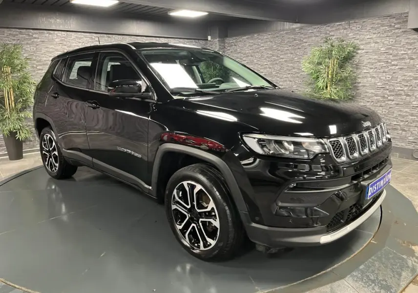 Jeep Compass 2024 noir en 3/4 avant droit, avec jantes alliage 18 pouces et calandre distinctive à sept fentes.