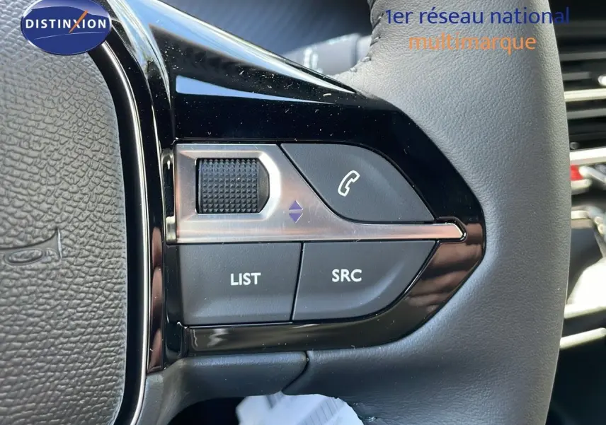 Gros plan sur les commandes au volant du Peugeot 2008 2025, finition Allure, avec cuir noir et boutons fonction audio.