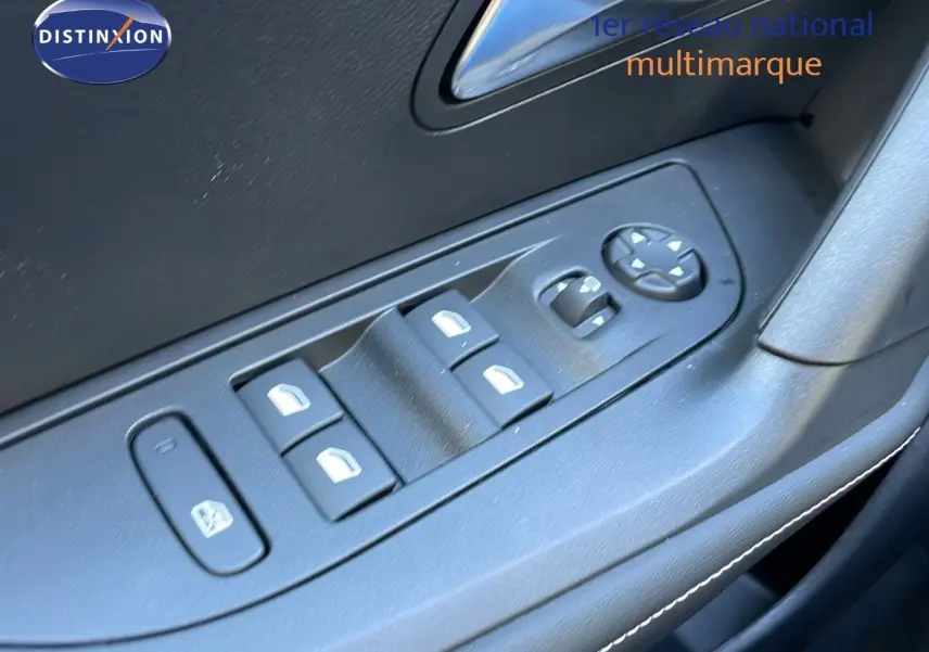 Gros plan sur les commandes des vitres électriques et rétroviseurs côté conducteur d'une Peugeot 2008 gris Artense 2025.