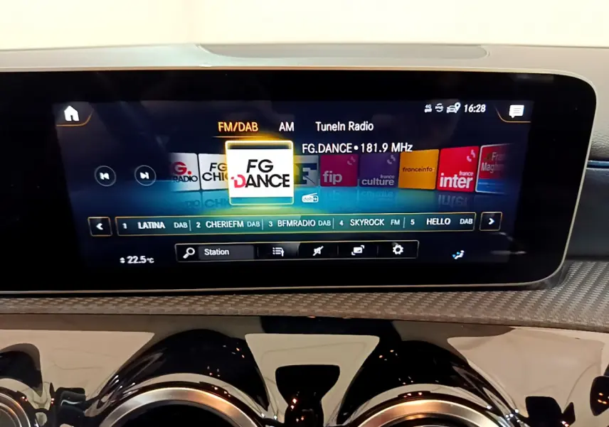 Écran tactile central affichant la radio FM/DAB dans l'habitacle d'une Mercedes Classe A gris clair, vue de face.