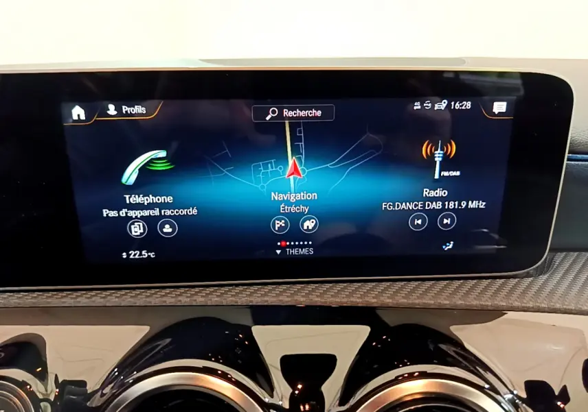 Écran tactile central affichant navigation, radio et téléphone dans le tableau de bord d'une Mercedes Classe A 180 d gris clair.