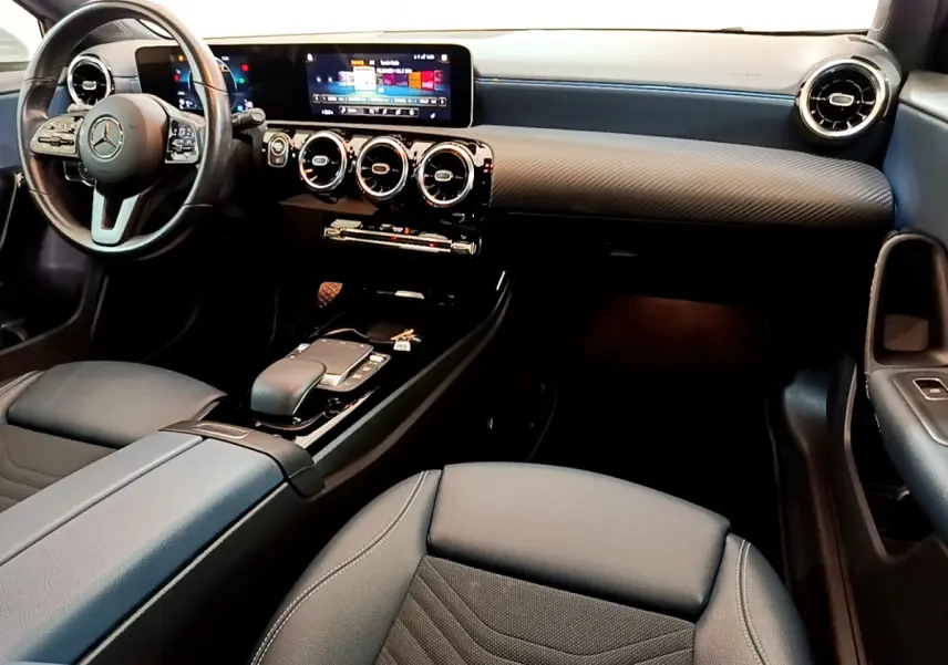 Intérieur de la Mercedes Classe A 180 d Business Line 2020, vue avant droite sur tableau de bord et sièges noirs.