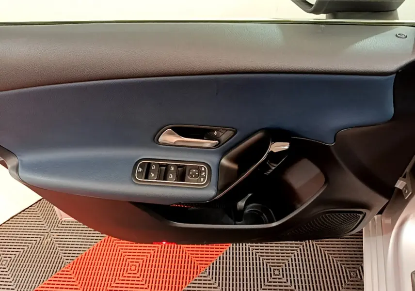 Vue rapprochée de la porte avant gauche gris clair de la Mercedes Classe A 180 d Business Line avec commandes électriques.