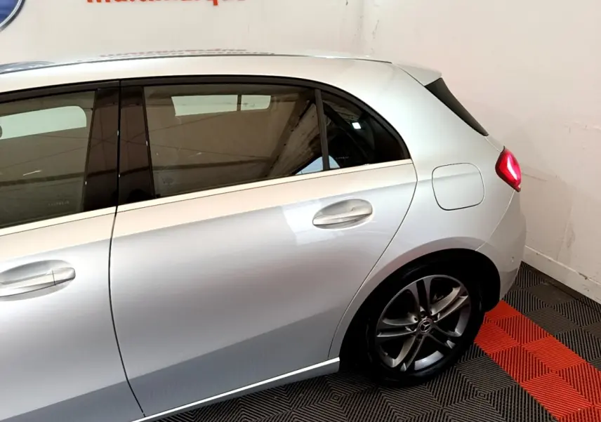 Vue latérale droite d'une Mercedes Classe A gris clair, mettant en valeur la porte arrière et la jante alliage sombre.