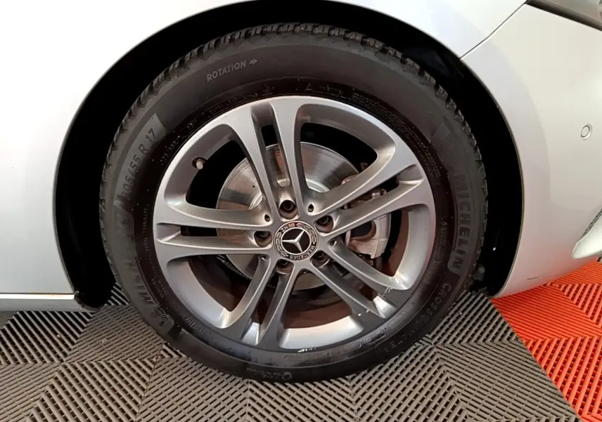 Gros plan sur la roue avant droite gris clair d'une Mercedes Classe A 180 d Business Line avec jante alliage et logo central étoile.