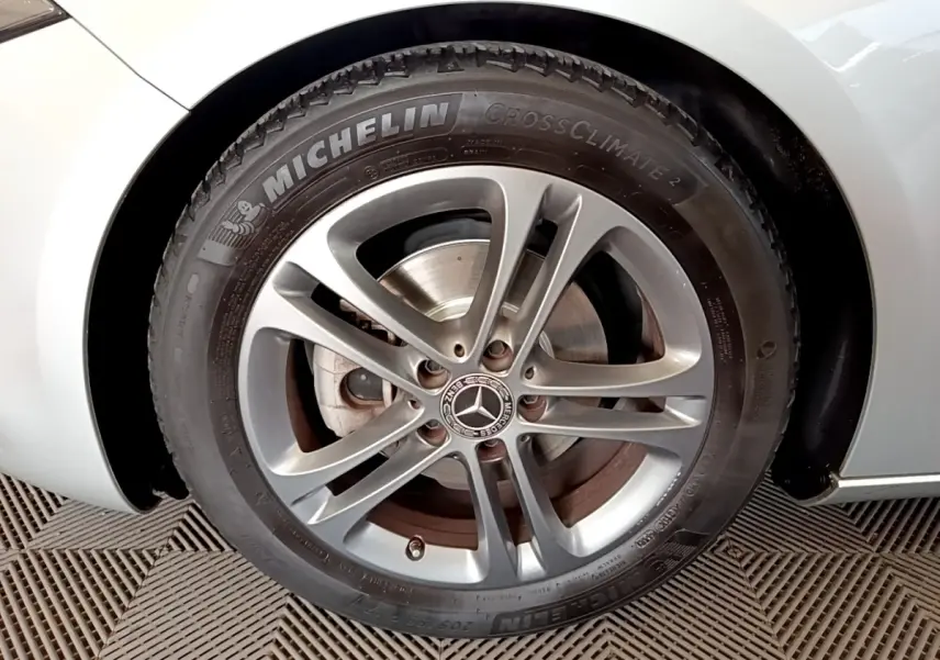 Gros plan sur la roue avant droite gris clair d'une Mercedes Classe A 180 d Business Line avec jante alliage et pneu Michelin.
