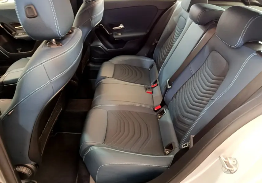 Vue intérieure côté droit montrant la banquette arrière noire avec surpiqûres blanches d'une Mercedes Classe A 180 d Business Line 2020.