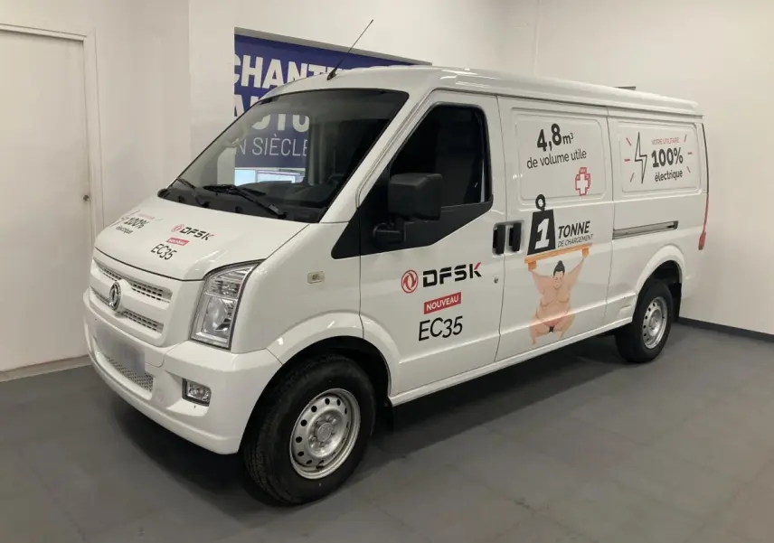 Vue 3/4 avant droit du fourgon blanc DFSK EC35 Ecocity 2022 avec marquages publicitaires électriques sur la carrosserie.