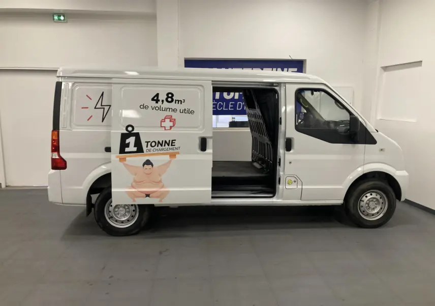 Vue de profil côté gauche d’un utilitaire blanc DFSK EC35 Ecocity 2022 avec porte coulissante ouverte et marquage de capacité de charge.
