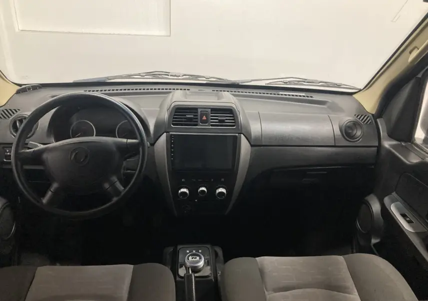 Vue intérieure frontale du tableau de bord noir du DFSK EC35 Ecocity 2022 avec volant, écran tactile et commande de boîte auto.