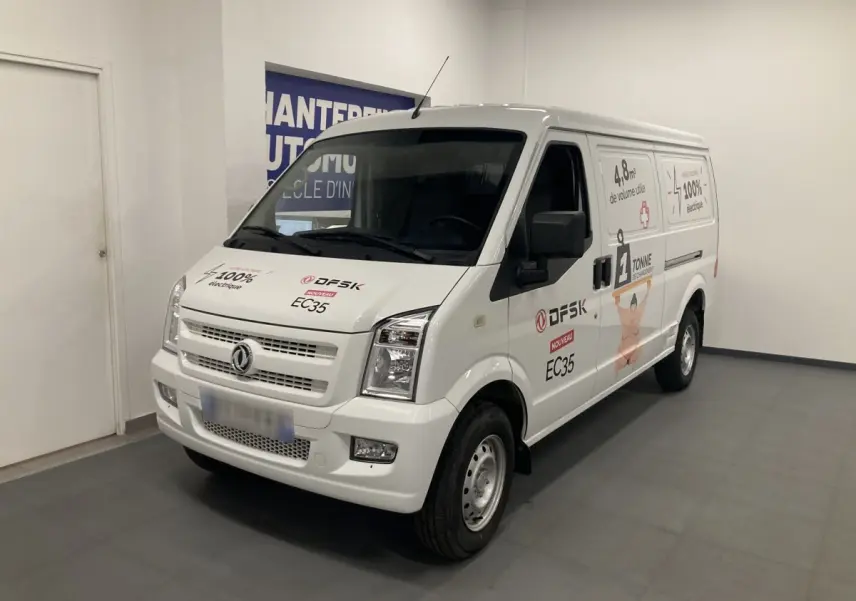 Vue 3/4 avant droit d’un utilitaire blanc DFSK EC35 Ecocity avec marquages publicitaires et logo électrique.