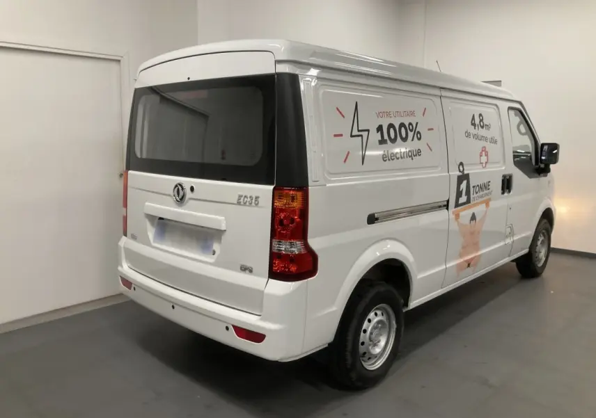 Vue 3/4 arrière droite du utilitaire blanc DFSK EC35 Ecocity avec marquages publicitaires électriques sur la porte latérale.