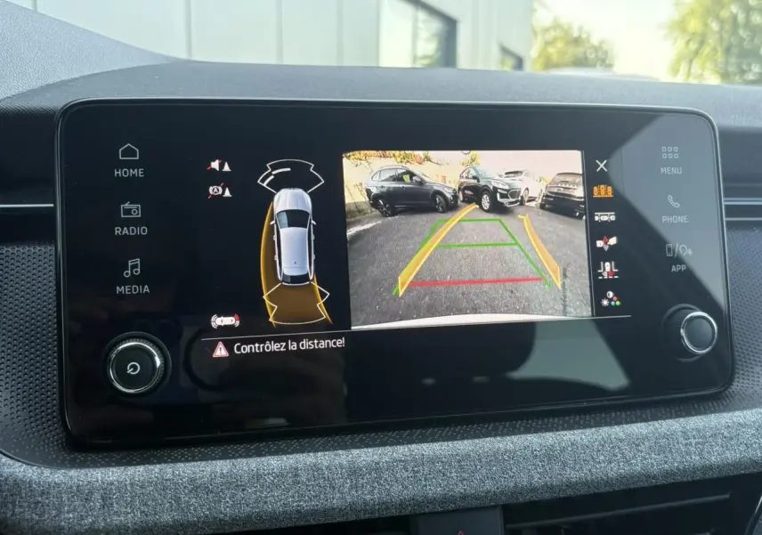 Écran central de la Skoda Scala TSI 116 DSG7 Sélection montrant la caméra de recul avec guidage dynamique.